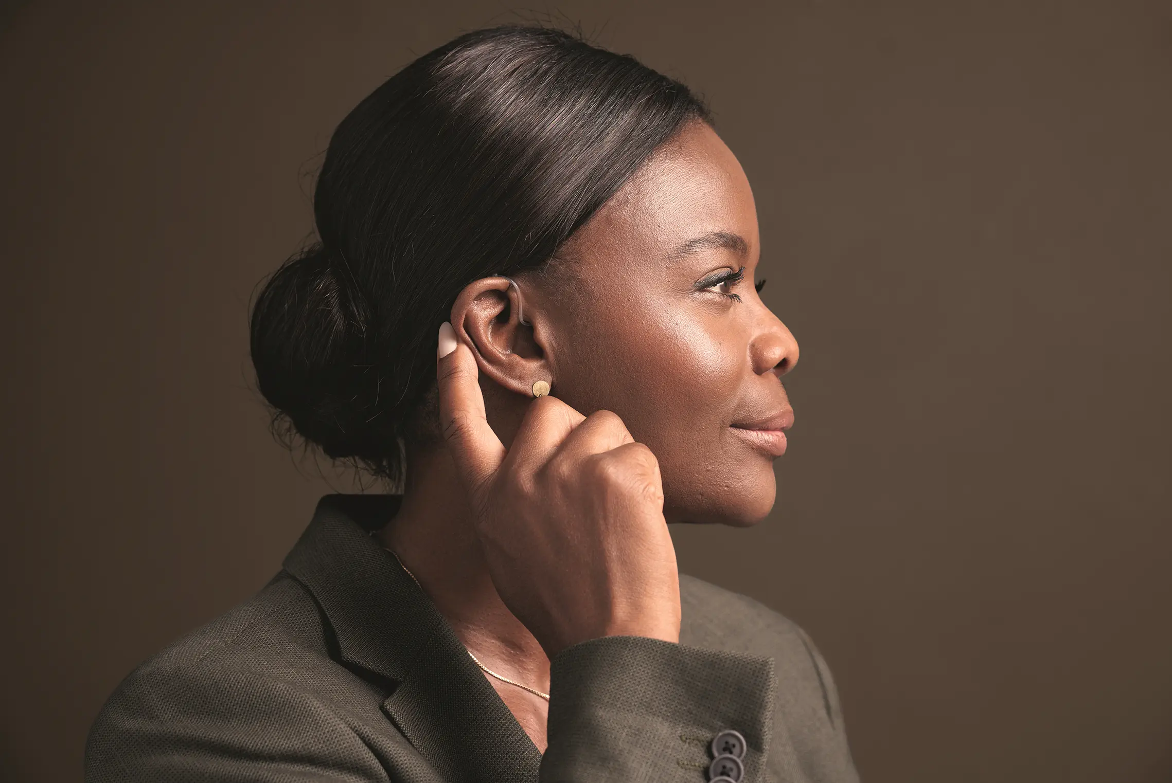 Jovem usando aparelho auditivo invisível intracanal para surdez leve