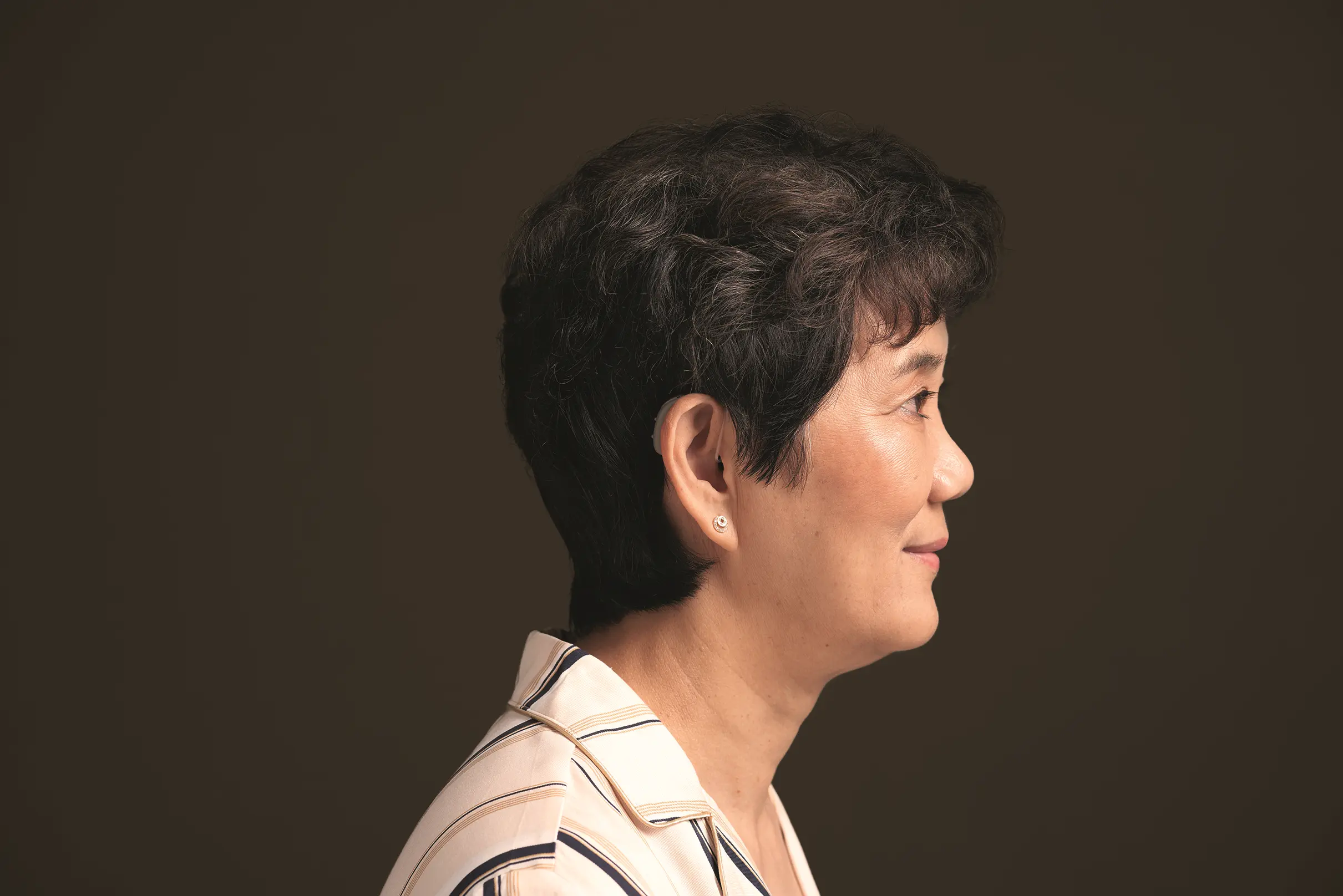 Senhora ouvindo música com clareza após exame de audiometria